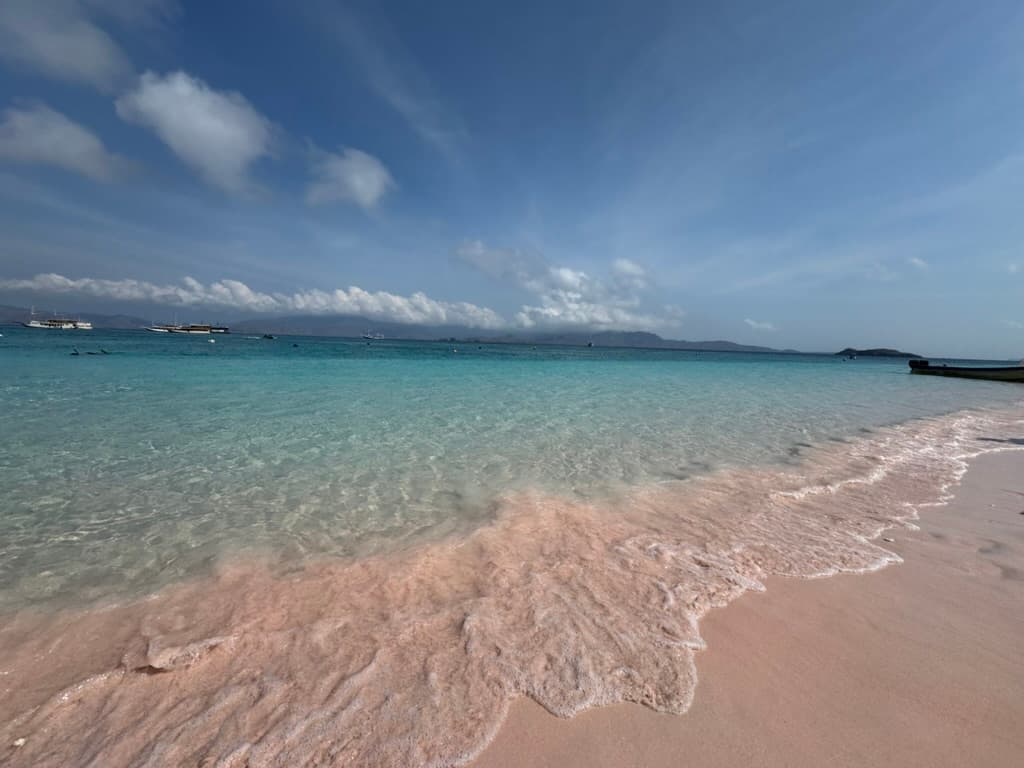 Pink Beach — the pink sand comes from red coral fragments mixed into the white sand