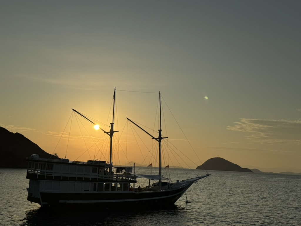 The liveaboard at anchor as the sun sets over the Flores Sea islands